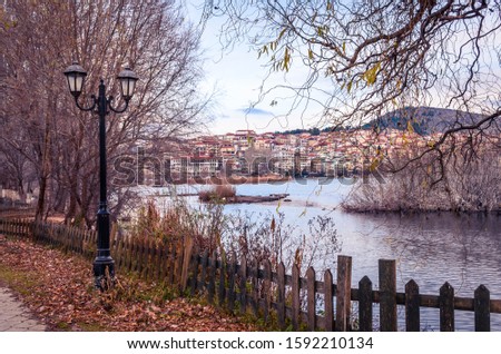 View of the city of Kastoria and Orestiada lake at sunset.Wodden fences and street lights decorate the beautiful promenade of the city.
