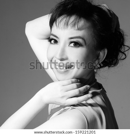 Cheerful asian lady posing in casuals isolated in black and white