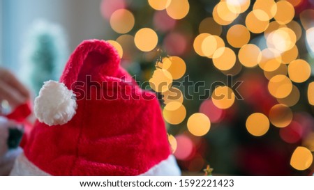 Santa Claus red hat with Christmas decorations against bokeh background, close up
