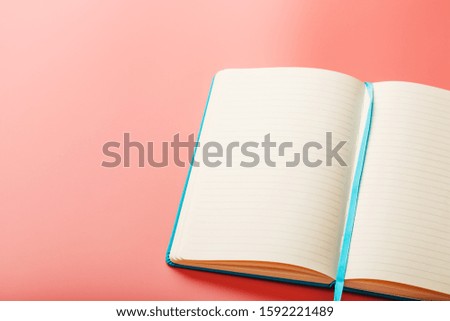 Open a laptop with blank pages on a pink background. Top view, copy space