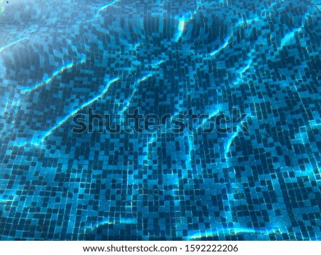 Blue Tiles at the Bottom of a Beautiful Blue Pool with Light Refracting Off of the Water's Surface