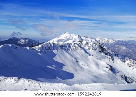 Snow-capped peaks of mountain .  Beautiful View of ski resort of Rosa Khutorin. Winter landscape with blue sky. 