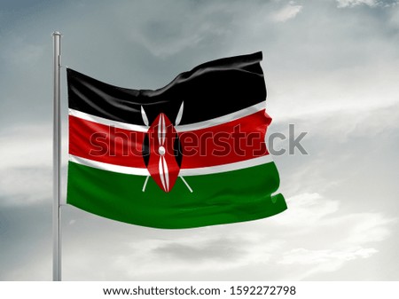 Kenya national flag cloth fabric waving on beautiful grey sky.