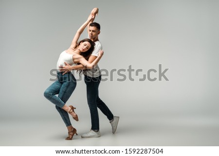 dancers with closed eyes dancing bachata on grey background Royalty-Free Stock Photo #1592287504