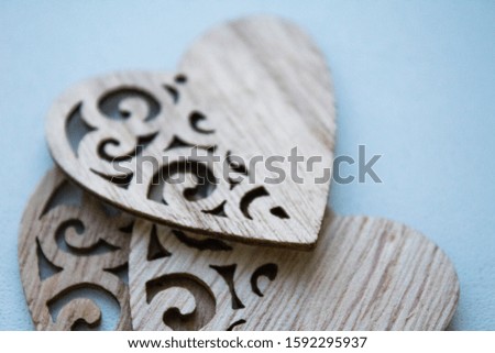 three carved wooden hearts superimposed on each other lie on a white background, Valentine's day concept