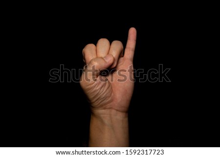 The man's hand holding the little finger shows the symbol of a contract or a request for reconciliation on black background.