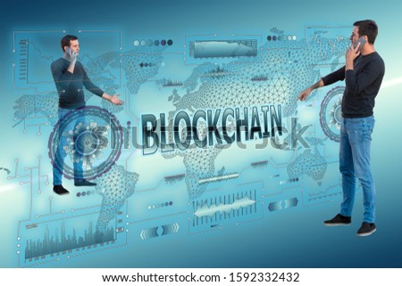 Businessmen are holding mobile smartphones between a crypto hologram with the words BLOCKCHAIN. Crypto background concept