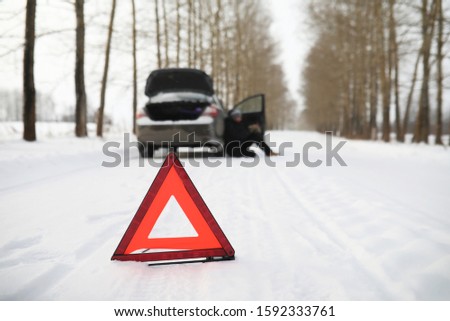 Man and car. Winter road walk and car repair.