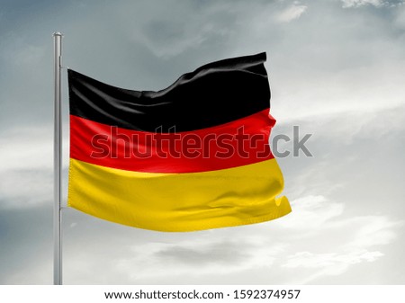 Germany national flag cloth fabric waving on beautiful grey sky.