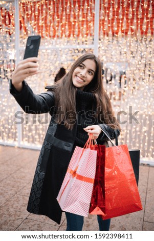 Woman taking selfie with black mobile phone