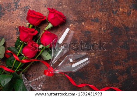 Valentine's day greeting card with red rose flowers and champagne glasses on wooden background Copy space Top view - Image
