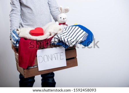 Happy child boy hold .donate box with clothes and kids toys. Donation and charity concept.  