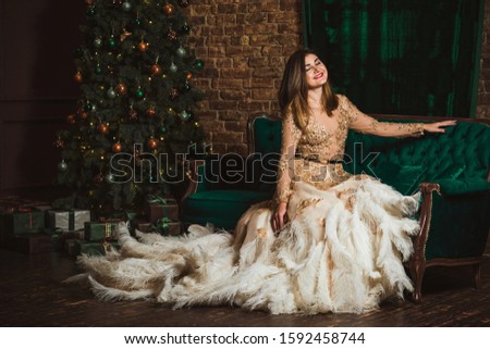 Magical night, arabic woman in feathers evening golden sparkle dress at Christmas atmosphere