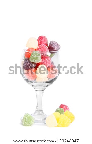 Sugary fruit gums in a glass with white background
