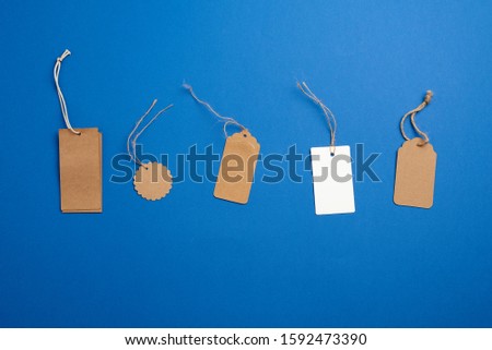 set of paper brown and white blank tags on a rope on a blue background. Vintage flat business template with paper brown tag empty for packaging design. Price tag label