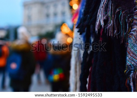 Partially blurred photo of a traditional Christmas fair with scarves and lights