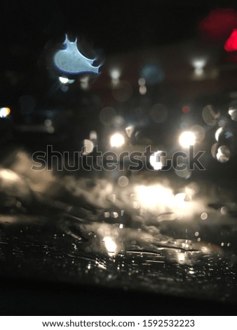 The picture is of a window with headlights and the rain with colorful blobs.