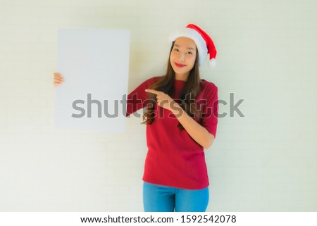 Portrait beautiful young asian women wear santa christmas hat show blank white board card with copy space