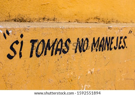 old yellow wall in Izamal Mexico. translation "if you drink dont drive" -spanish