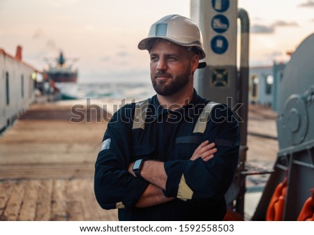 Marine Deck Officer or Chief mate on deck of offshore vessel or ship , wearing PPE personal protective equipment - helmet, coverall Royalty-Free Stock Photo #1592558503