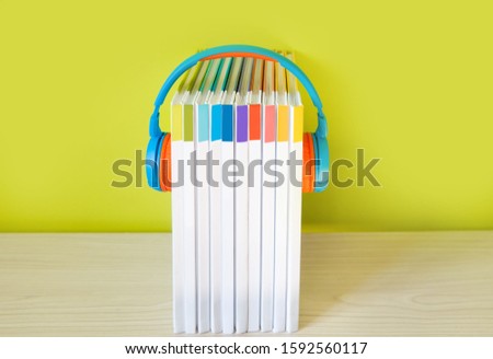 Colorful Headphones and books on color background. Concept of au