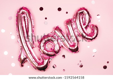 Love foil balloon on monochrome colorful backdrop. Valentines day concept.