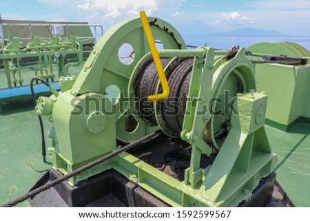 Boat reels on ferry from Bali to Lombok in Indonesia. Electrically powered mechanisms for lowering the anchor and winding the mooring ropes. Strong chains and marine ropes to anchor the ship to pier.