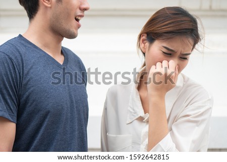 woman suffering from man bad breath, concept of tooth decay, gingivitis, poor oral hygiene, bad breath or ordor smell from unhealthy mouth, poor personality, oral hygiene health care Royalty-Free Stock Photo #1592642815