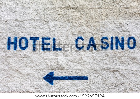 Hotel Casino text painted on the wall directs customers to the entrance to logging and gambling facility.