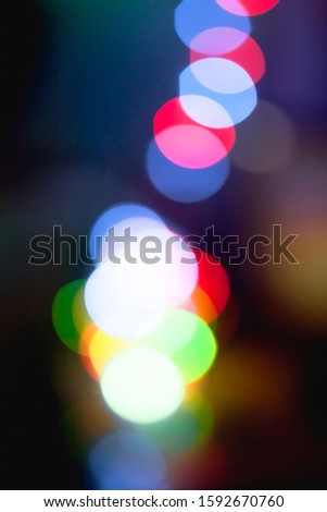 Abstract unfocused vertical background - Multi color  bokeh of different bubbles on a black background. Modern blurred pattern for design and for Christmas, New year and funny holiday backdrops.
