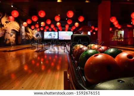 Bowling lane and balls in the row in bowling center.
