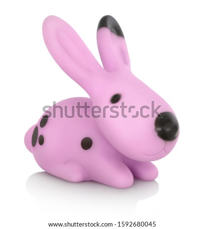 Stylish cute plastic pink rabbit toy. Isolated on white background with shadow reflection. With clipping path. Pink hare with black stains on white bg. Cape hare on white underlay.