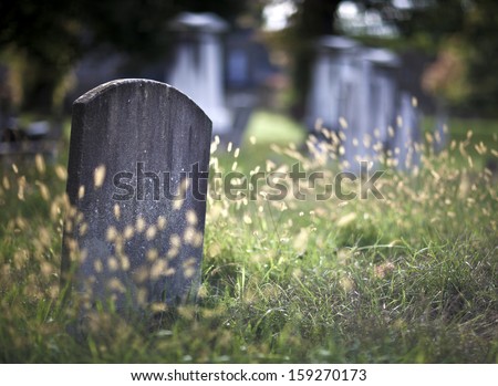 Tombstone and graves in an ancient church graveyard Royalty-Free Stock Photo #159270173