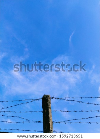 clear blue sky behind the roof and fence