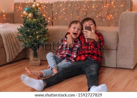 Two brothers take selfie on a smartphone for the new year. Merry Christmas.