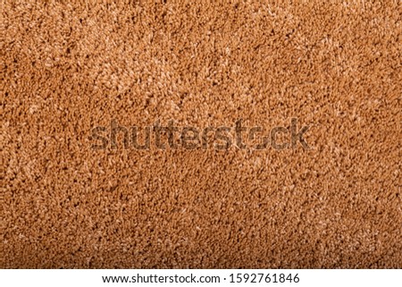 Carpet covering background. Pattern and texture of orange colour carpet. Copy space.