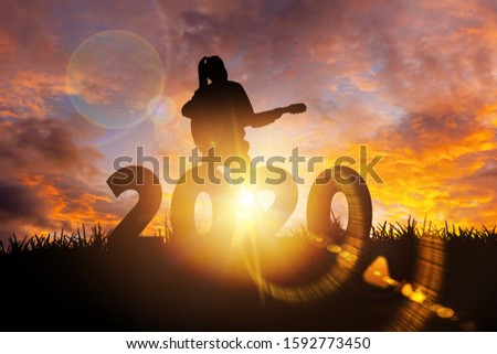 2020 New Year : Young woman playing guitar and relaxing with music on 2020 New Year,  Happy new year concept