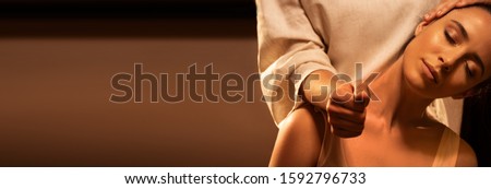Young pretty woman has Thai massage. Close up of neck stretching. Warm inviting colors, calm atmosphere, charming light. Concept of serene spa treatments. Extended background for design. Royalty-Free Stock Photo #1592796733