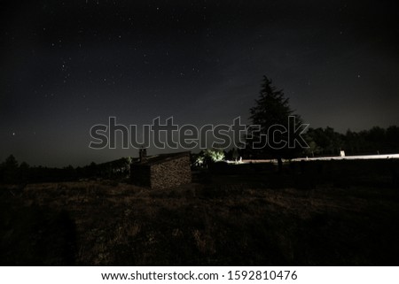 Photography of a house in the mountain with stars