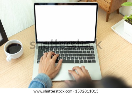 mockup image blank screen computer with white background for advertising text,hand man using laptop contact business search information on desk at home office.marketing and creative design