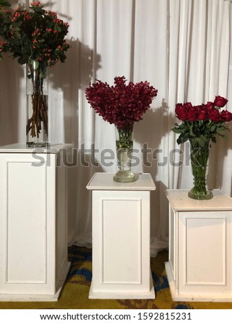 flower vases in a row. abundance group of floral decorations with white background of beautiful waves of curtain.