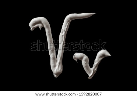 letter V of the latin alphabet .white oil paint on black.