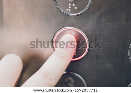 Close up of finger pressing elevator floor button