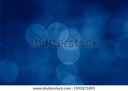 abstract  pale blurred circular bokeh lights background toned in trendy pantone Classic Blue color of the Year 2020