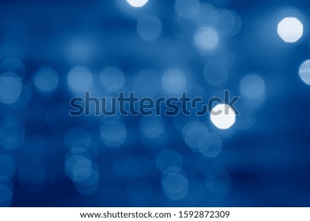 abstract blurred circular bokeh lights background toned in trendy pantone Classic Blue color of the Year 2020