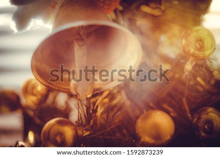 Golden bell and balls on the Christmas tree close-up, warm light