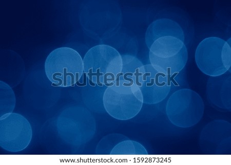 abstract blurred circular bokeh lights background toned in trendy pantone Classic Blue color of the Year 2020
