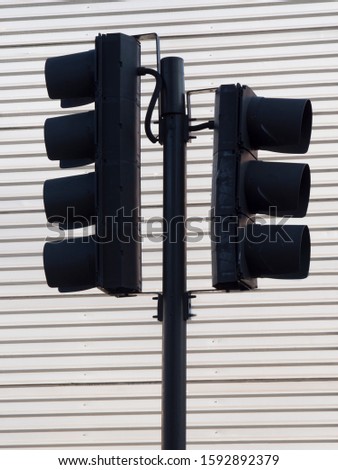 Image shows UK traffic light cluster from the side and silhouetted against a white background