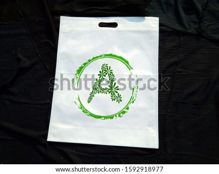 Green Letter A Print on White non woven bag isolated on black background