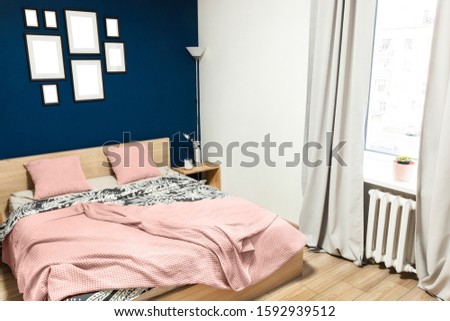 Interior of the room in light colors. Bedroom with a bed and a cot in colors classic blue 2020